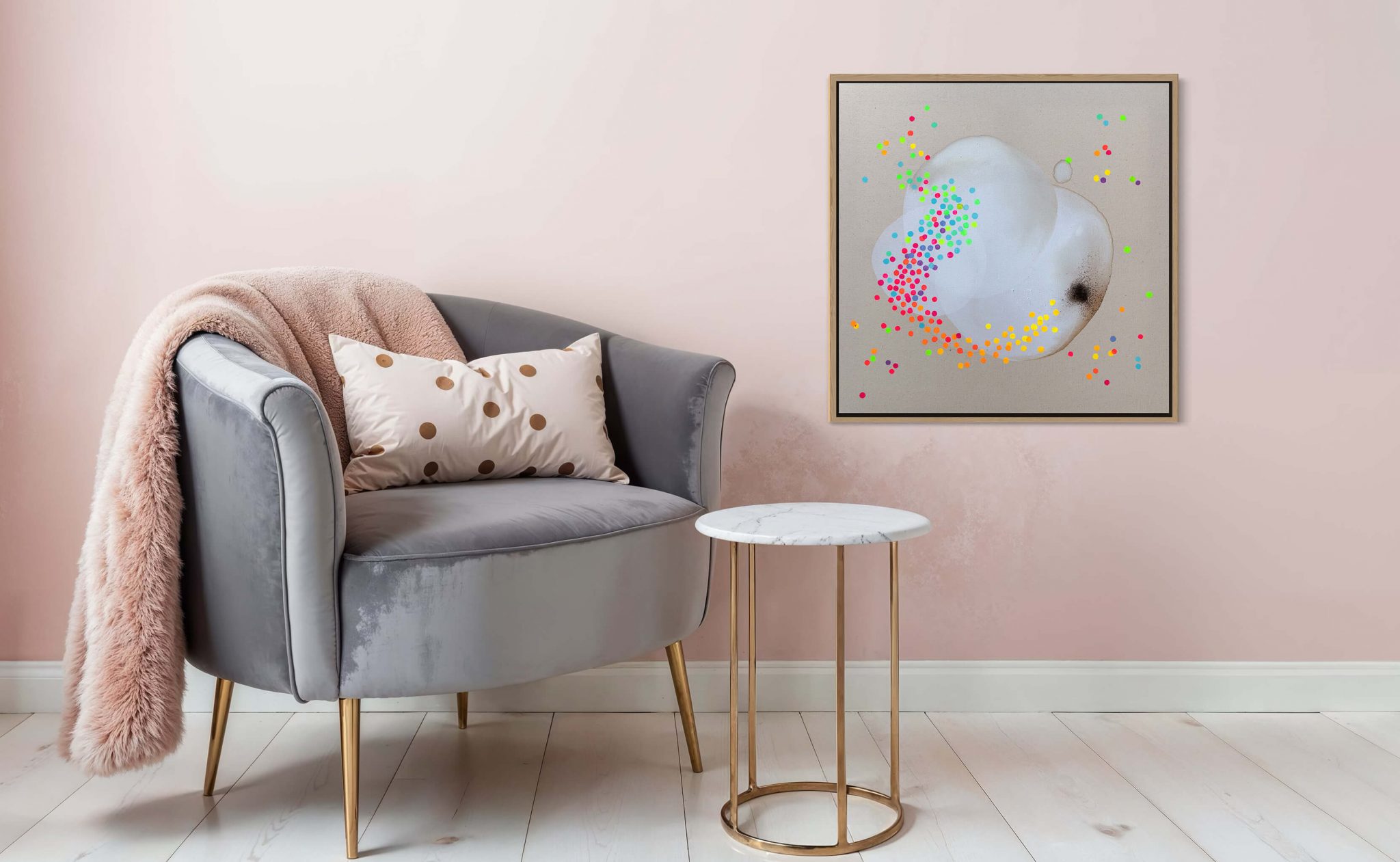 Kunstwerk-haengt an einer rosafarbenen Wand-neben einem grauen Sessel